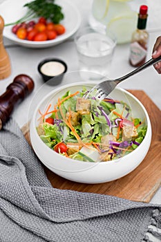 A hand held fork Fresh fruit salad with vegetables and vegetarian nutrition for health