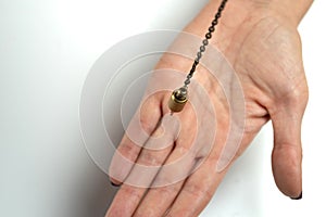 Hand-held pendulum over the arm of a dowser. photo
