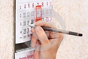 Hand highlighting date on calendar