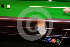 Hand hitting white ball with cue