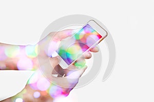 Hand hoding smart phone with bokeh.