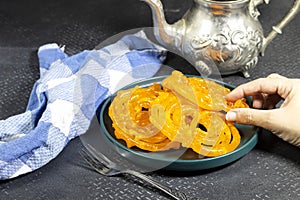 Hand hold algeria sweet food named zlabia, in Inde named Jalebi, it is prepared with flour and yogurt and honey and other ingredie photo