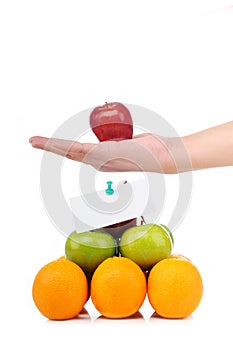 A hand hold an apple on fruit pyramid