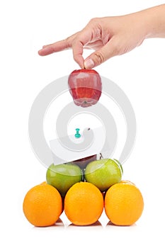 A hand hold an apple on fruit pyramid