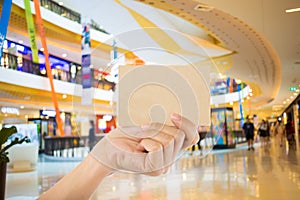 Hand hold blank business card in the shopping mall.