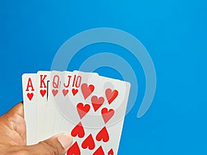 Hand hold card games against blue background. Poker games and gambling concept.