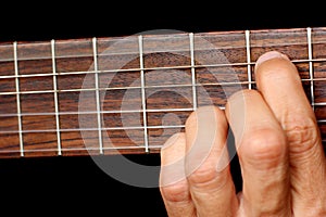 Hand, hold a chord on the guitar fretboard, vibrating string