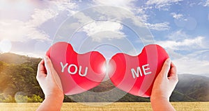 Hand hold couple red heart with text you and me on nature background