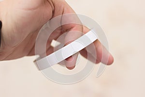 Hand hold double-sided adhesive paper  on white background