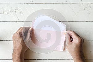 Hand hold a envelope and paper on wooden background