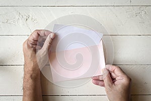 Hand hold a envelope and paper on wooden background