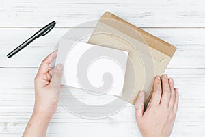 Hand hold a envelope and paper on the wooden background