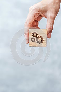 Hand hold gear block with business goal, strategy, teamwork, target, mission, action, objective, brainstorming  and success