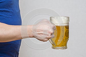 Hand hold glass mug of beer on white background. Beer in a glass holding by hand