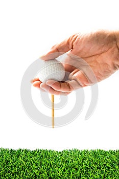 Hand hold golf ball with tee on course