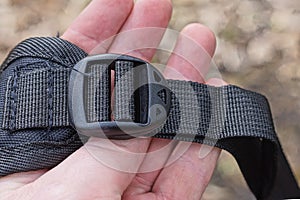 hand hold a one closed small black plastic carabiner