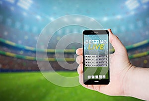 Hand hold a phone with betting online on a screen