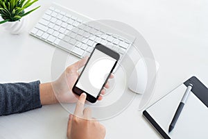 Hand hold phone and touching on workspace table