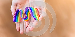 Hand hold a rainbow of LGBT tapes on a LIGHT background. Copy space The concept of homosexuals and LGBT people.