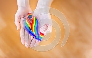 Hand hold a rainbow of LGBT tapes on a LIGHT background. Copy space The concept of homosexuals and LGBT people.