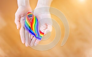 Hand hold a rainbow of LGBT tapes on a LIGHT background. Copy space The concept of homosexuals and LGBT people.