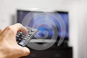 Hand hold remote control in front of tv