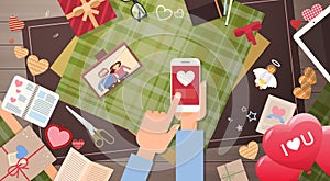 Hand Hold Smart Phone Valentine Day Gift Card Holiday Decorated Workspace Desk Top Angle View