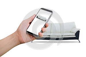Hand hold smartphone, tablet, cell phone with blank screen on blurry modern black and white sofa, Online shopping decoration conc