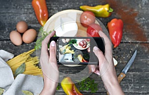 Hand hold smartphone woman takes photo healthy food for blog,photographer food