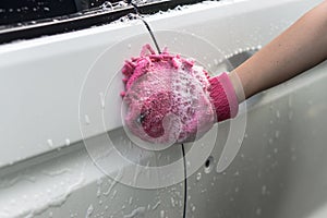 Hand hold sponge over the car for washing.