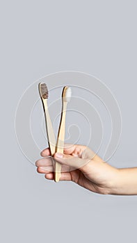 Hand hold bamboo eco tooth brush. Grey background