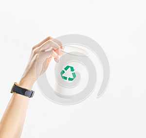 Hand hold up an empty takeaway paper cup with green recycle symbol on white background