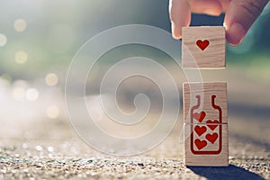 Hand hold wooden cube with heart sign icon on and copy space nature sunlight you can put text on background. Valentine love season