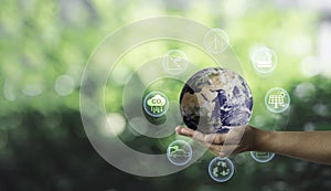 Hand hold world on greenery background and CO2 reducing for decrease carbon footprint and credit to limit global warming from