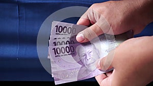 Hand holding 10.000 Rupiah money. Indonesia currency ten thousand Rupiah