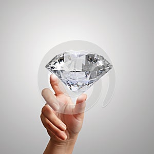 Hand holding 3d diamond over white