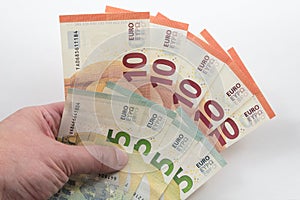 Hand holding 5 and 10 Euro notes