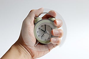 A hand holding an alarm clock. photo