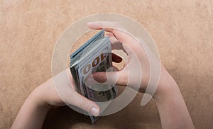 Hand holding American dollar on wooden background