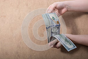 Hand holding American dollar on wooden background