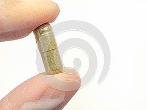 Hand holding of Andrographis paniculata capsule  on white background.