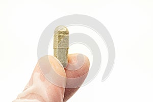 Hand holding of Andrographis paniculata capsule  on white background.