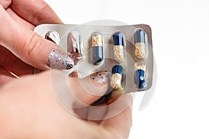 Hand holding antibiotics capsules or painkillers isolated on white. Medicine concept, pills close up, copy space
