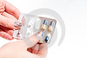 Hand holding antibiotics capsules or painkillers isolated on white. Medicine concept, pills close up, copy space