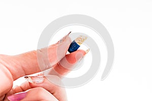 Hand holding antibiotics capsules or painkillers isolated on white. Medicine concept, pills close up, copy space