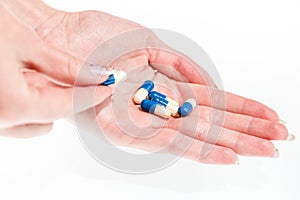 Hand holding antibiotics capsules or painkillers isolated on white. Medicine concept, pills close up, copy space