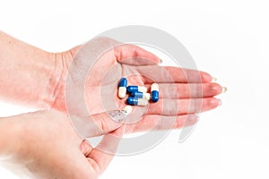 Hand holding antibiotics capsules or painkillers isolated on white. Medicine concept, pills close up, copy space