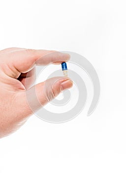 Hand holding antibiotics capsules or painkillers isolated on white. Medicine concept, pills close up, copy space