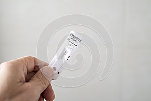 Hand holding an antigen test for coronavirus or SARS CoV2 or covid, with negative result, on a white background photo