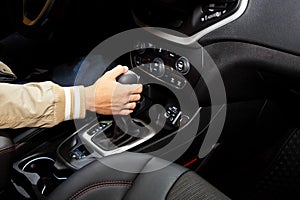 Hand holding automatic transmission in car